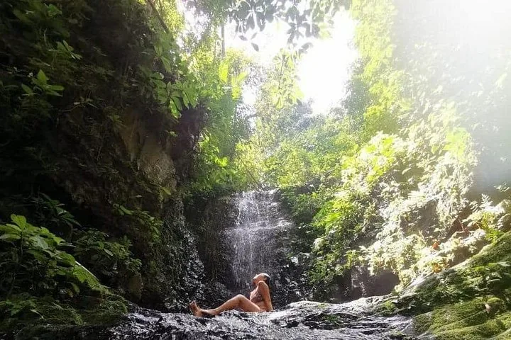 Frau entspannt an einem kleinen Wasserfall im Dschungel von Taman Negara.