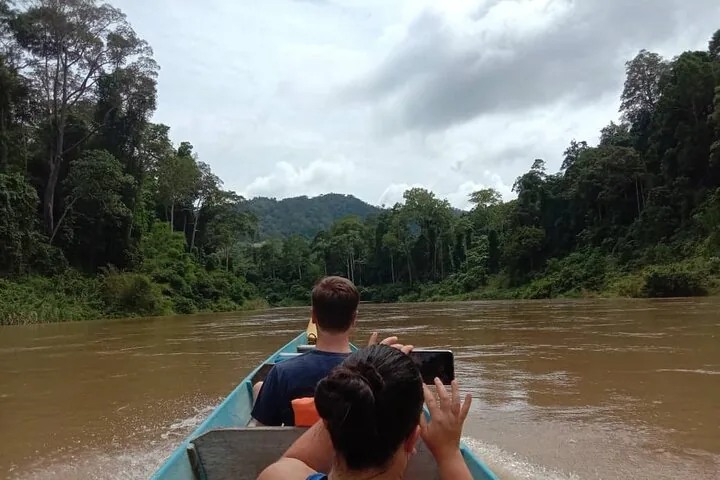 Toeristen tijdens een boottocht over een brede rivier in Taman Negara.