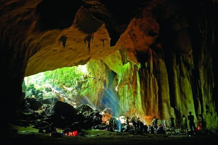 Touristen, die eine große Höhle im Taman Negara Nationalpark erkunden.